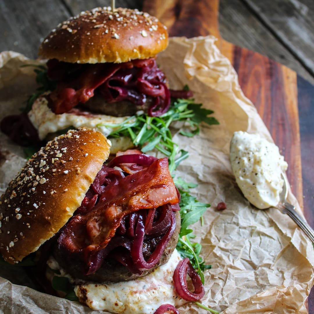 Högrevsburgare med rödvinskokt rödlök, bacon, ost och rucola